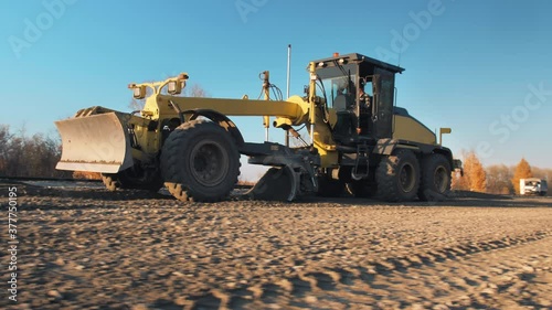 Grader with 3D GPS System. Satellite navigation. A motor grader levels bulk building materials for a new road construction. Road surface repair. Road construction machines. Road works