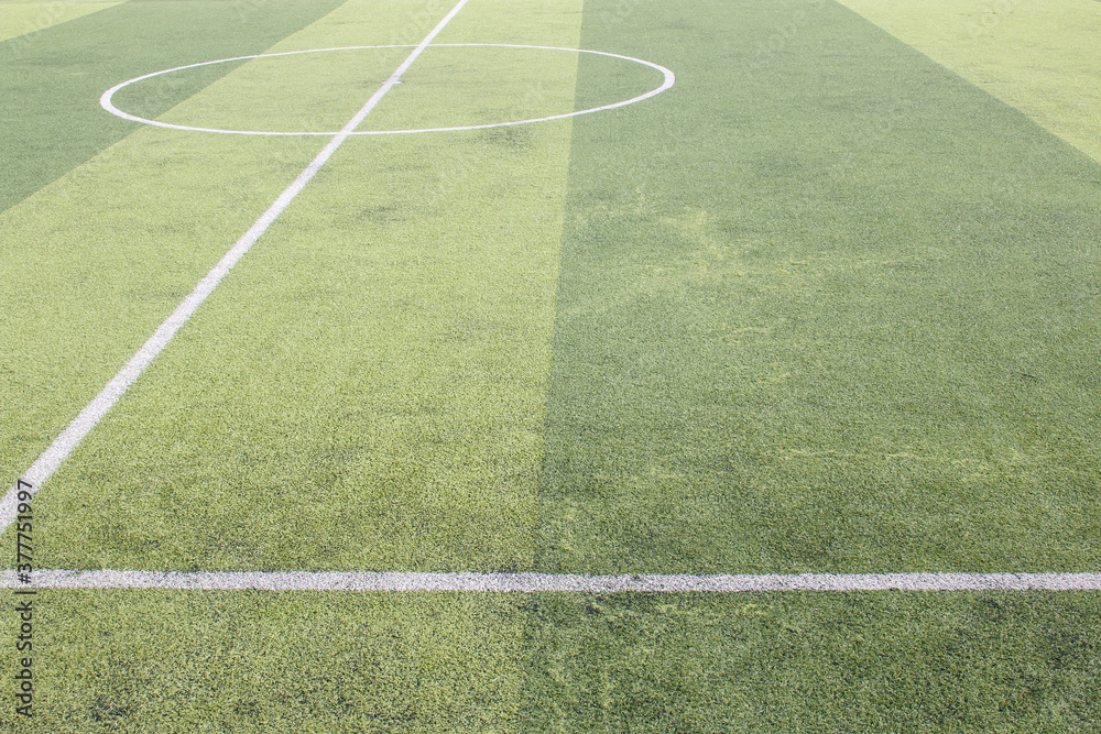 Obraz premium Photo of a green synthetic grass sports field with white line shot from above.