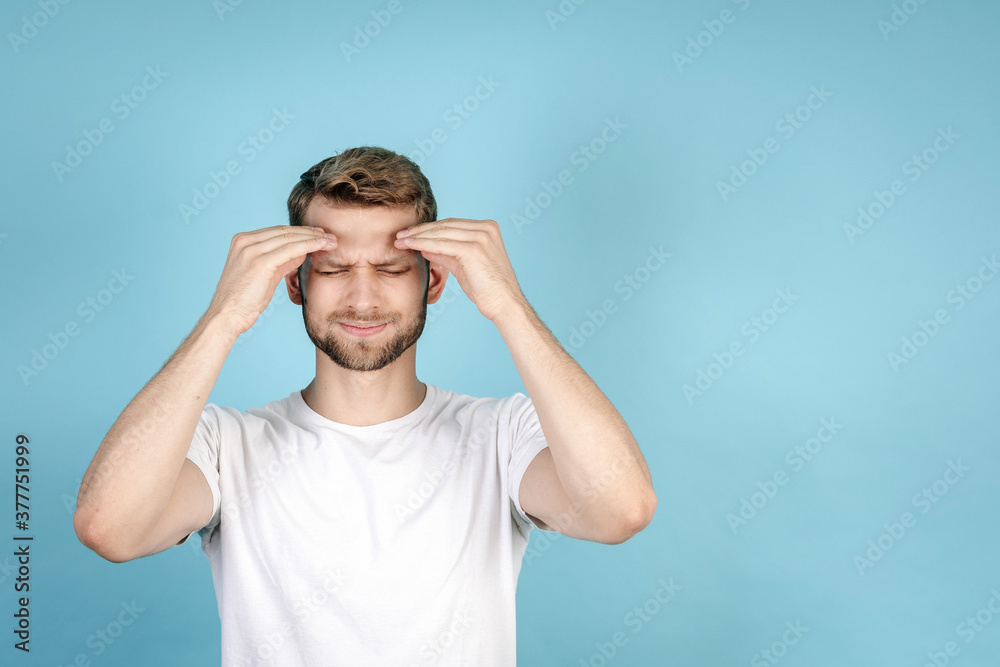 Young guy touching forehead and feeling headache Young guy touching forehead and feeling headache