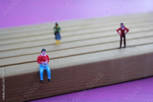 social distancing covid-19 covid concept of people mini model figures apart background with copy space, queue with lines and social distance  photo