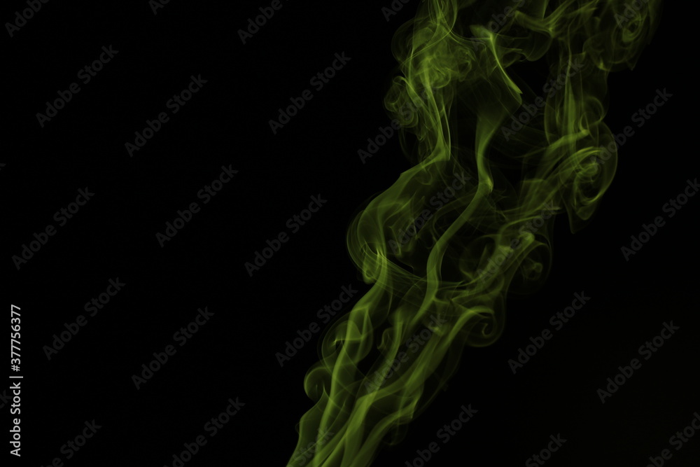 yellow smoke from incense on a black background