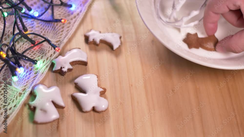 Person decorating gingerbread cookies for Christmas. Person decorating gingerbread cookies for Christmas.