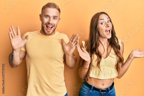 Young couple of girlfriend and boyfriend hugging and standing together celebrating crazy and amazed for success with arms raised and open eyes screaming excited. winner concept