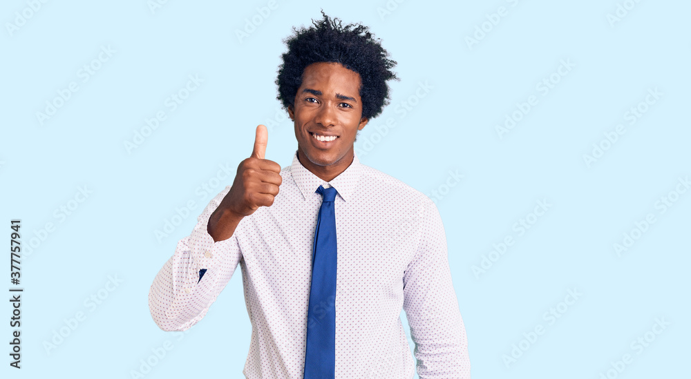 Handsome african american man with afro hair wearing business clothes smiling happy and positive, thumb up doing excellent and approval sign Handsome african american man with afro hair wearing business clothes smiling happy and positive, thumb up doing excellent and approval sign