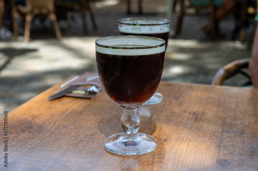 Glasses with cold dark strong Belgian beer served outdoor Glasses with cold dark strong Belgian beer served outdoor