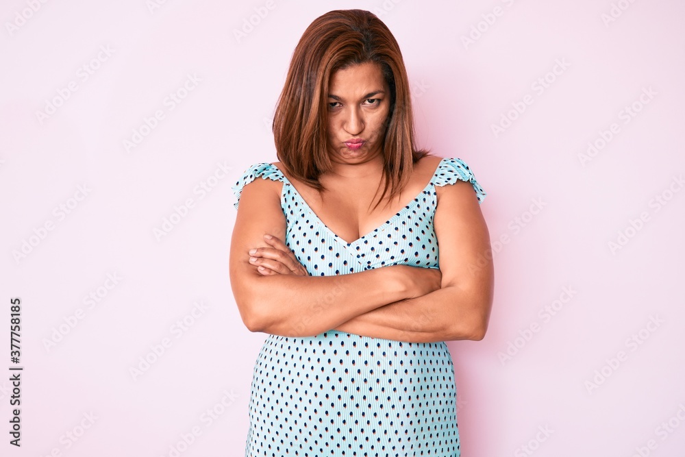 Middle age brunette hispanic woman wearing summer dress skeptic and nervous, disapproving expression on face with crossed arms. negative person. Middle age brunette hispanic woman wearing summer dress skeptic and nervous, disapproving expression on face with crossed arms. negative person.