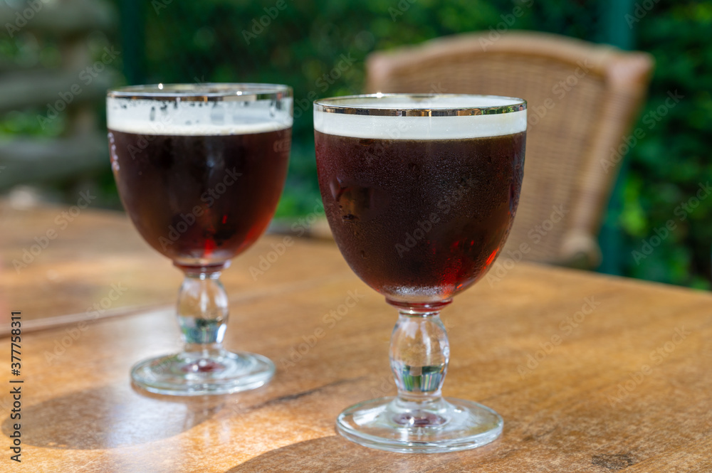 Glasses with cold dark strong Belgian beer served outdoor Glasses with cold dark strong Belgian beer served outdoor