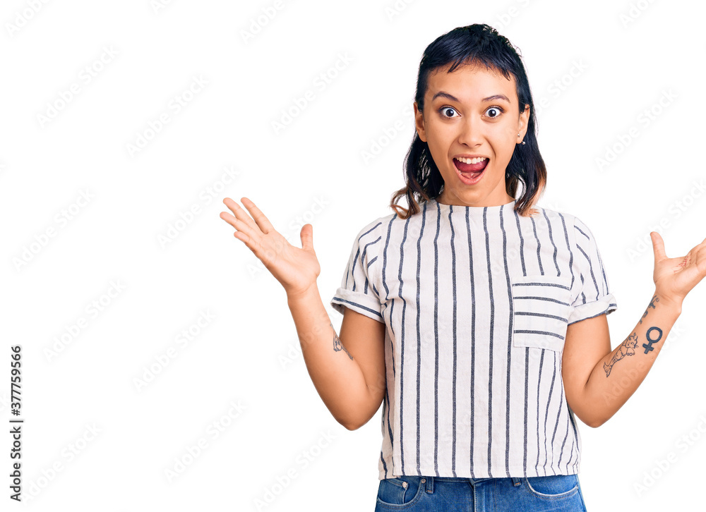 Young woman wearing casual clothes celebrating crazy and amazed for success with arms raised and open eyes screaming excited. winner concept Young woman wearing casual clothes celebrating crazy and amazed for success with arms raised and open eyes screaming excited. winner concept