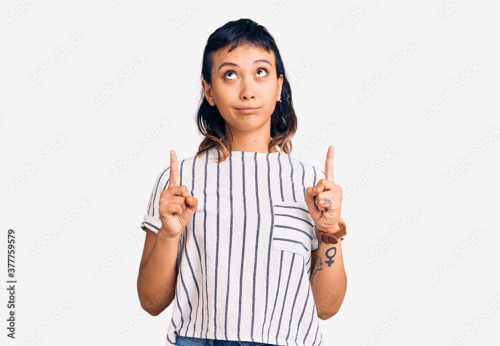 Young woman wearing casual clothes pointing up looking sad and upset, indicating direction with fingers, unhappy and depressed. Young woman wearing casual clothes pointing up looking sad and upset, indicating direction with fingers, unhappy and depressed.
