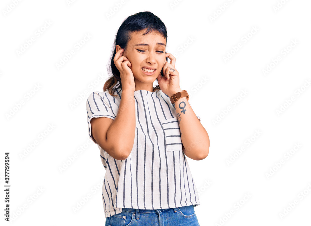 Young woman wearing casual clothes covering ears with fingers with annoyed expression for the noise of loud music. deaf concept. Young woman wearing casual clothes covering ears with fingers with annoyed expression for the noise of loud music. deaf concept.