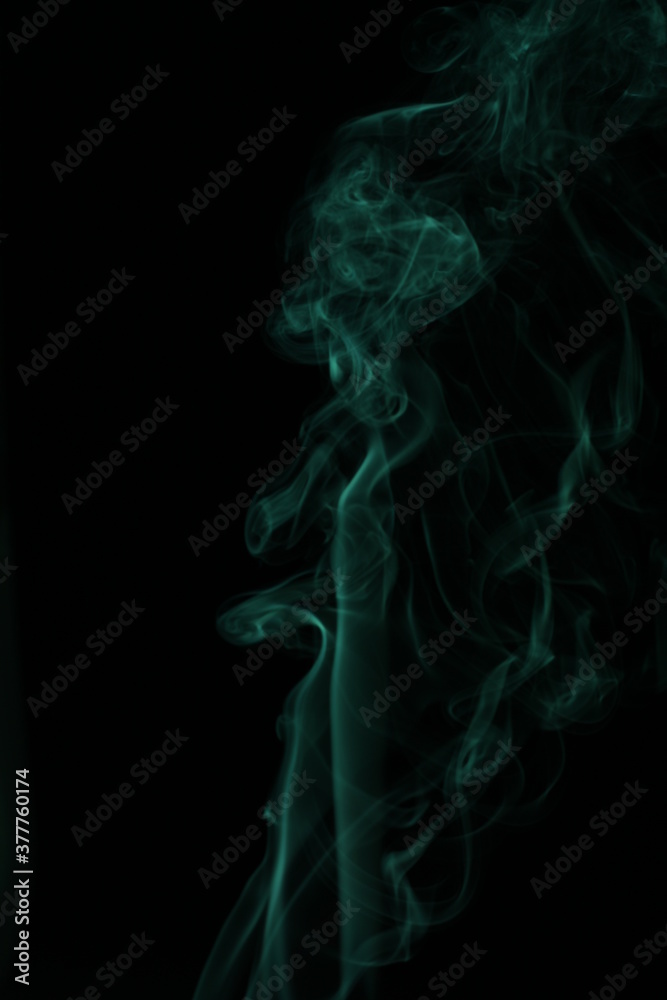 green smoke from incense on a black background green smoke from incense on a black background