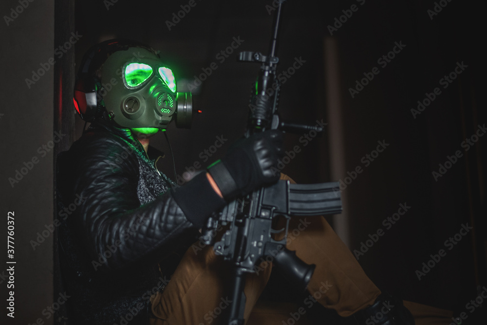 Futuristic soldier in the gas mask with a rifle in the dark hall. Futuristic soldier in the gas mask with a rifle in the dark hall.