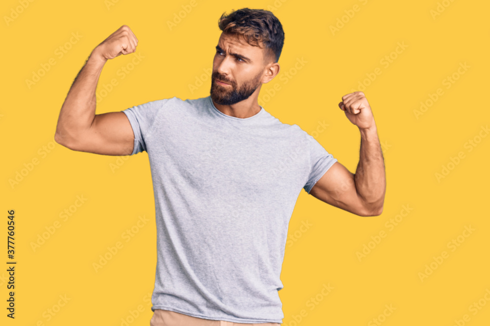 Young hispanic man wearing casual clothes showing arms muscles smiling proud. fitness concept. Young hispanic man wearing casual clothes showing arms muscles smiling proud. fitness concept.