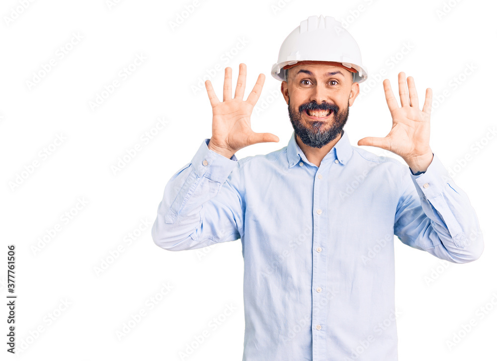 Young handsome man wearing architect hardhat showing and pointing up with fingers number ten while smiling confident and happy. Young handsome man wearing architect hardhat showing and pointing up with fingers number ten while smiling confident and happy.
