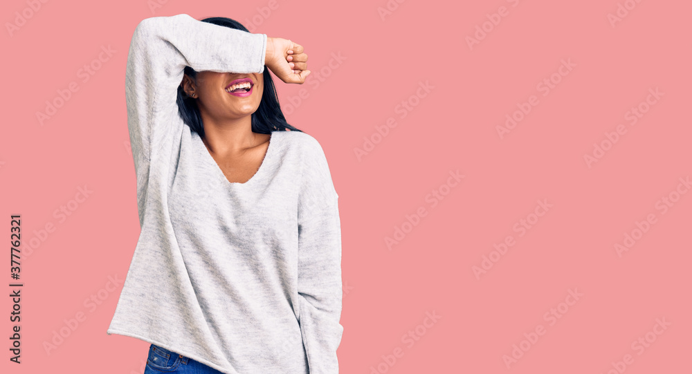 Hispanic woman with long hair wearing casual clothes covering eyes with arm smiling cheerful and funny. blind concept. Hispanic woman with long hair wearing casual clothes covering eyes with arm smiling cheerful and funny. blind concept.