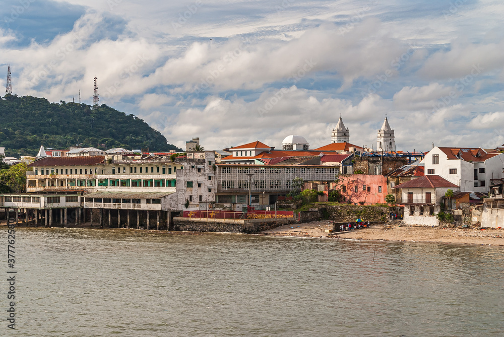 Panama City, Panama - November 30, 2008: Seen from French Park, looking to shoreline with dilapidated historic hotels on stilts and the towers of Cathedral Basilica of Santa Maria La Antigua.