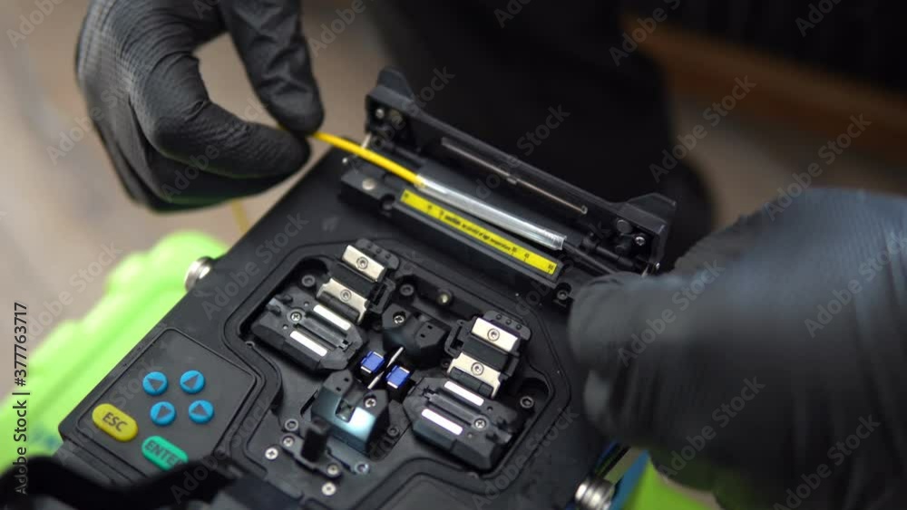 The technicians welding optical fiber cable with fusion splicing fiber optic Machine