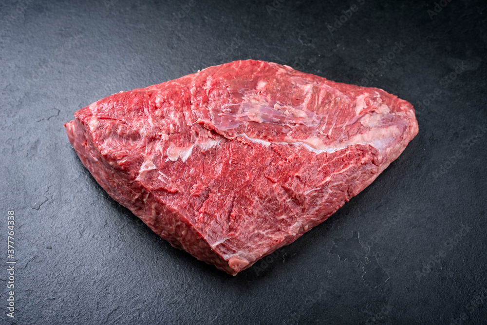 Raw dry aged wagyu cap of rump beef offered as close-up on black background with copy space