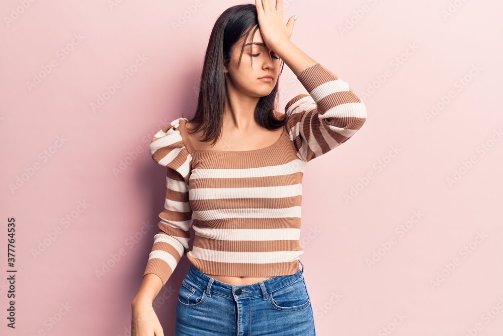 Young beautiful girl wearing casual striped t shirt surprised with hand on head for mistake, remember error. forgot, bad memory concept. Young beautiful girl wearing casual striped t shirt surprised with hand on head for mistake, remember error. forgot, bad memory concept.