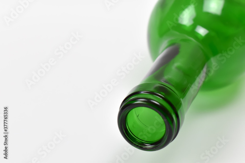 Zielone, szklana butelka na białym tle.