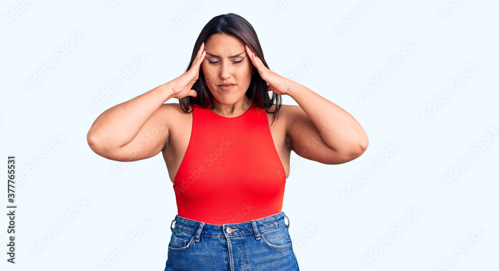 Young beautiful brunette woman wearing casual sleevelss t-shirt suffering from headache desperate and stressed because pain and migraine. hands on head. Young beautiful brunette woman wearing casual sleevelss t-shirt suffering from headache desperate and stressed because pain and migraine. hands on head.