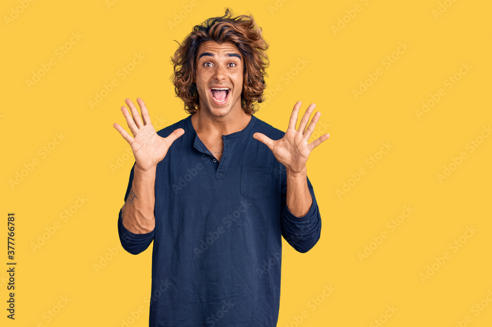 Young hispanic man wearing casual clothes celebrating crazy and amazed for success with arms raised and open eyes screaming excited. winner concept Young hispanic man wearing casual clothes celebrating crazy and amazed for success with arms raised and open eyes screaming excited. winner concept