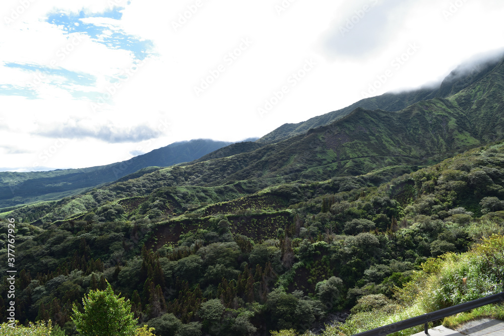Obraz premium Image of Aso mountains, clouds and sky over the grass