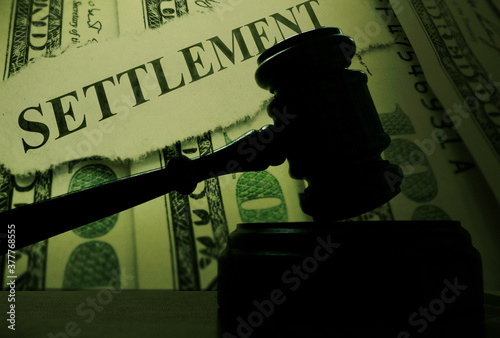 judge legal gavel with money and Settlement text