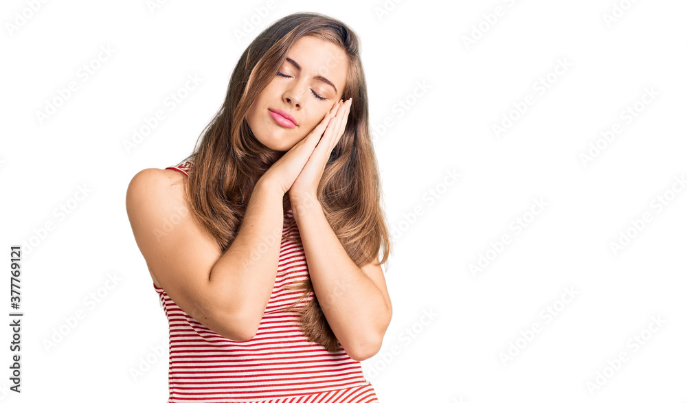 Beautiful caucasian young woman wearing casual clothes sleeping tired dreaming and posing with hands together while smiling with closed eyes. Beautiful caucasian young woman wearing casual clothes sleeping tired dreaming and posing with hands together while smiling with closed eyes.