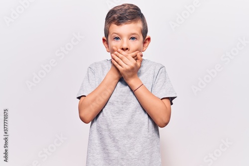 Cute blond kid wearing casual clothes shocked covering mouth with hands for mistake. secret concept.