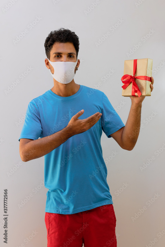 Pandemic masked man holding a gift isolated Pandemic masked man holding a gift isolated