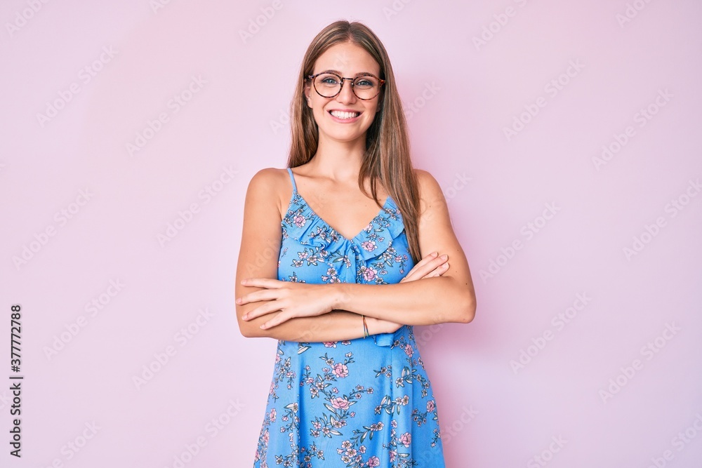 Young blonde girl wearing casual clothes and glasses happy face smiling with crossed arms looking at the camera. positive person. Young blonde girl wearing casual clothes and glasses happy face smiling with crossed arms looking at the camera. positive person.