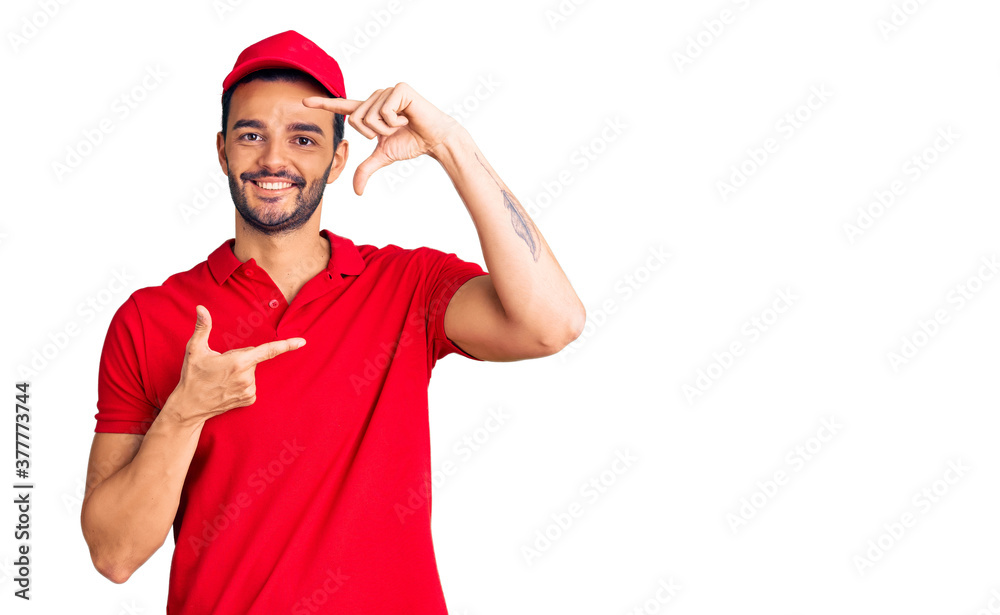 Young handsome hispanic man wearing delivery courier uniform smiling making frame with hands and fingers with happy face. creativity and photography concept.