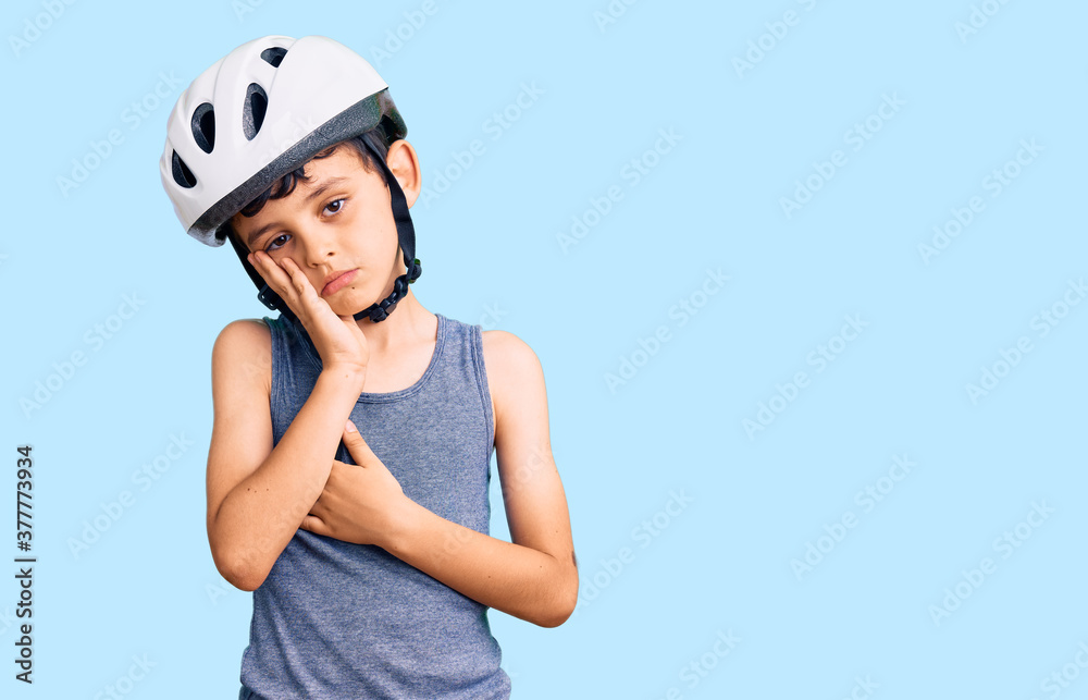 Little cute boy kid wearing bike helmet thinking looking tired and bored with depression problems with crossed arms. Little cute boy kid wearing bike helmet thinking looking tired and bored with depression problems with crossed arms.