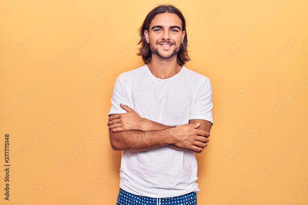 Young handsome man wearing casual clothes happy face smiling with crossed arms looking at the camera. positive person. Young handsome man wearing casual clothes happy face smiling with crossed arms looking at the camera. positive person.