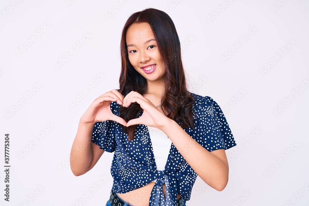 Φωτογραφία Young beautiful chinese girl wearing casual clothes smiling in love showing heart symbol and shape with hands