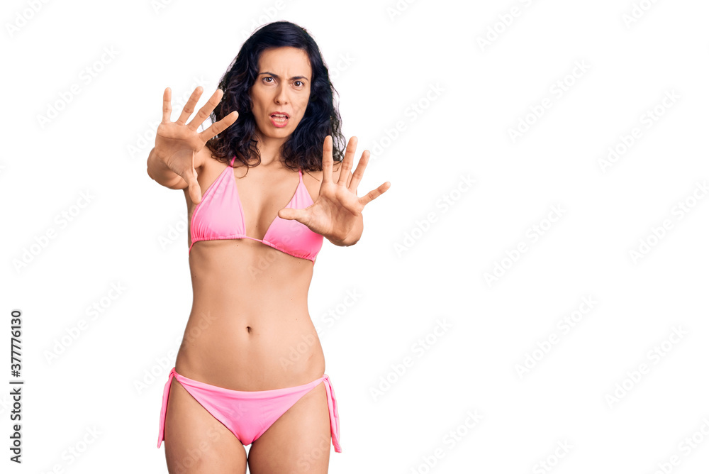 Young beautiful hispanic woman wearing bikini doing stop gesture with hands palms, angry and frustration expression Young beautiful hispanic woman wearing bikini doing stop gesture with hands palms, angry and frustration expression