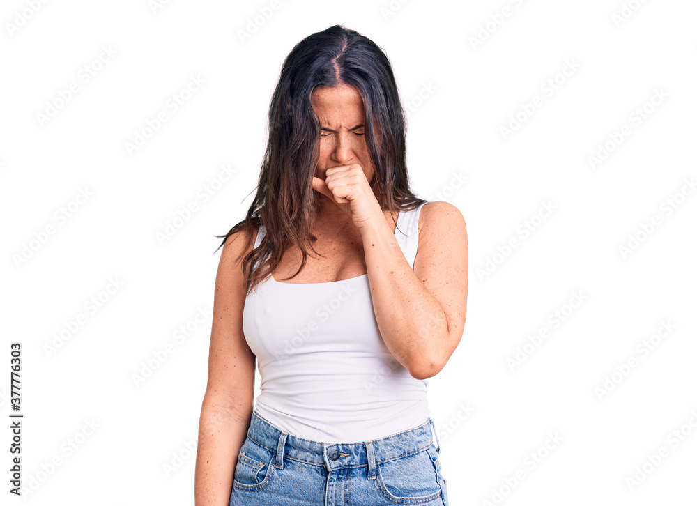 Young beautiful brunette woman wearing casual sleeveless t-shirt feeling unwell and coughing as symptom for cold or bronchitis. health care concept. Young beautiful brunette woman wearing casual sleeveless t-shirt feeling unwell and coughing as symptom for cold or bronchitis. health care concept.