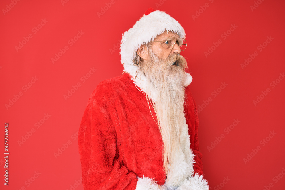 Old senior man with grey hair and long beard wearing traditional santa claus costume with hand on stomach because nausea, painful disease feeling unwell. ache concept.