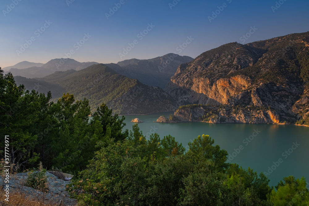 Green Canyon - one of the main attractions of Turkey. Natural beauty of Turkey. Mountains, green pines, turquoise lake. Mountain landscape with forest, trees. Beautiful mountain lake backround. Rocks.