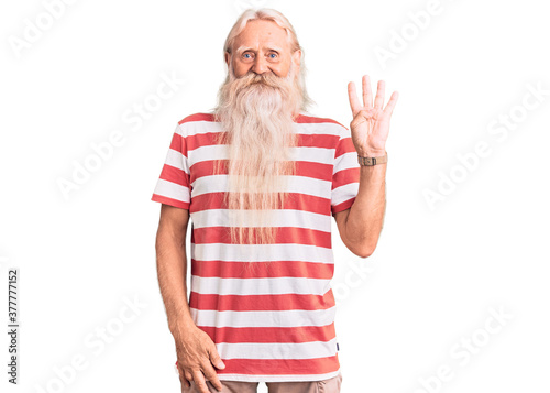 Old senior man with grey hair and long beard wearing striped tshirt showing and pointing up with fingers number four while smiling confident and happy.