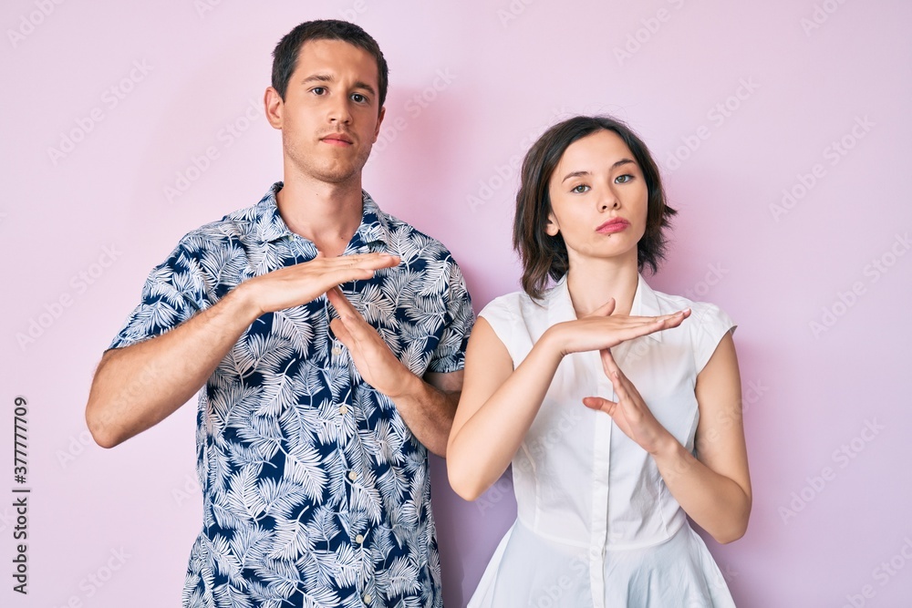 Beautiful couple wearing casual clothes doing time out gesture with hands, frustrated and serious face Beautiful couple wearing casual clothes doing time out gesture with hands, frustrated and serious face