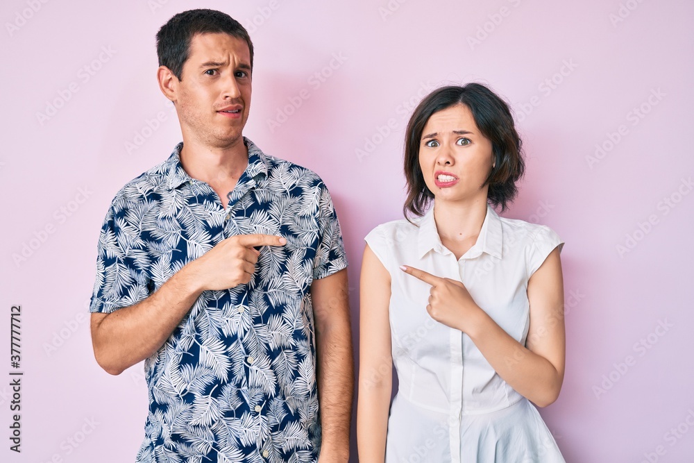 Beautiful couple wearing casual clothes pointing aside worried and nervous with forefinger, concerned and surprised expression Beautiful couple wearing casual clothes pointing aside worried and nervous with forefinger, concerned and surprised expression
