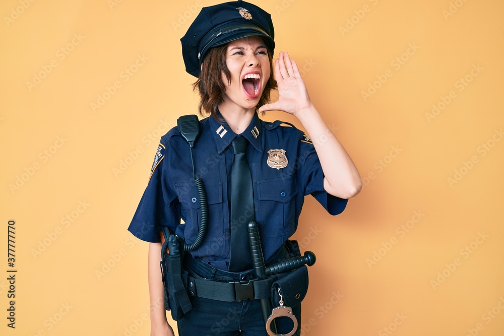 Young beautiful woman wearing police uniform shouting and screaming loud to side with hand on mouth. communication concept. Young beautiful woman wearing police uniform shouting and screaming loud to side with hand on mouth. communication concept.