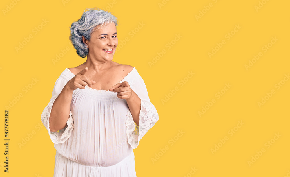 Senior woman with gray hair wearing bohemian style pointing fingers to camera with happy and funny face. good energy and vibes. Senior woman with gray hair wearing bohemian style pointing fingers to camera with happy and funny face. good energy and vibes.