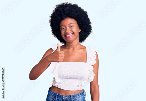 Young african american woman wearing casual clothes doing happy thumbs up gesture with hand. approving expression looking at the camera showing success.