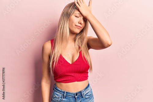 Young blonde woman wearing casual clothes surprised with hand on head for mistake, remember error. forgot, bad memory concept.