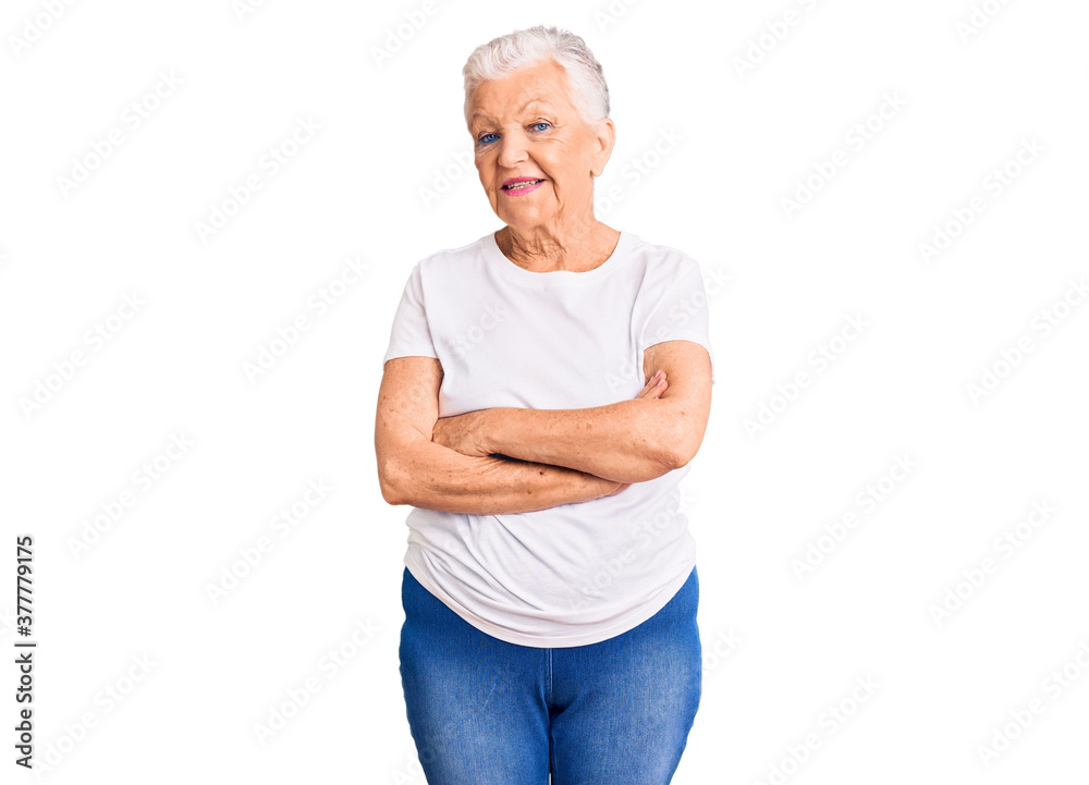 Senior beautiful woman with blue eyes and grey hair wearing casual white tshirt happy face smiling with crossed arms looking at the camera. positive person. Senior beautiful woman with blue eyes and grey hair wearing casual white tshirt happy face smiling with crossed arms looking at the camera. positive person.