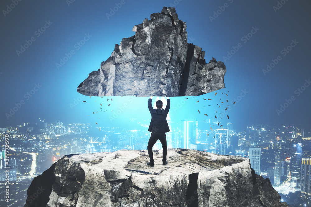 Fotografie Businessman holding rock.