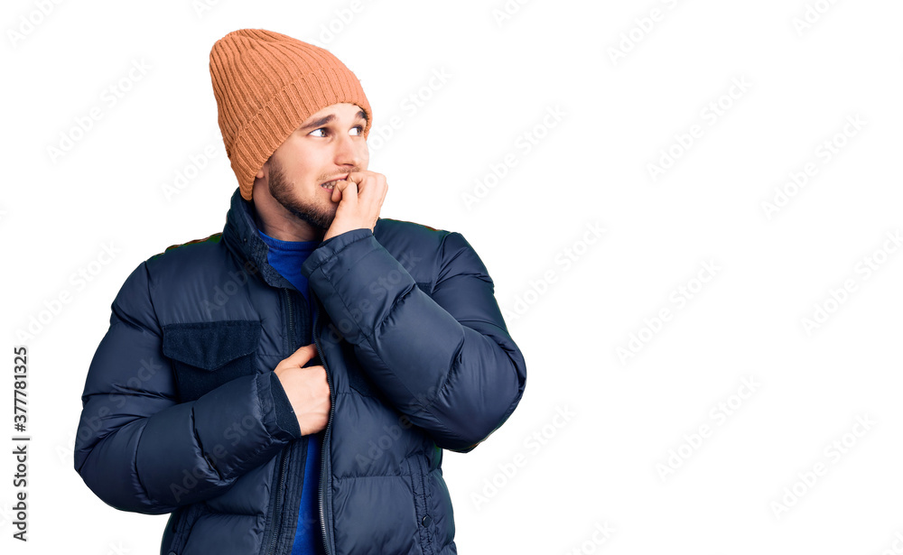 Young handsome man wearing winter clothes looking stressed and nervous with hands on mouth biting nails. anxiety problem. Young handsome man wearing winter clothes looking stressed and nervous with hands on mouth biting nails. anxiety problem.